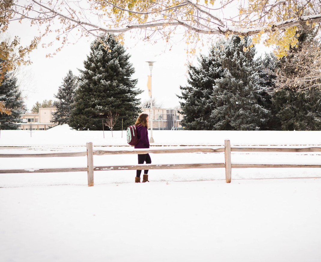 UNC student walking in the snow on campus.